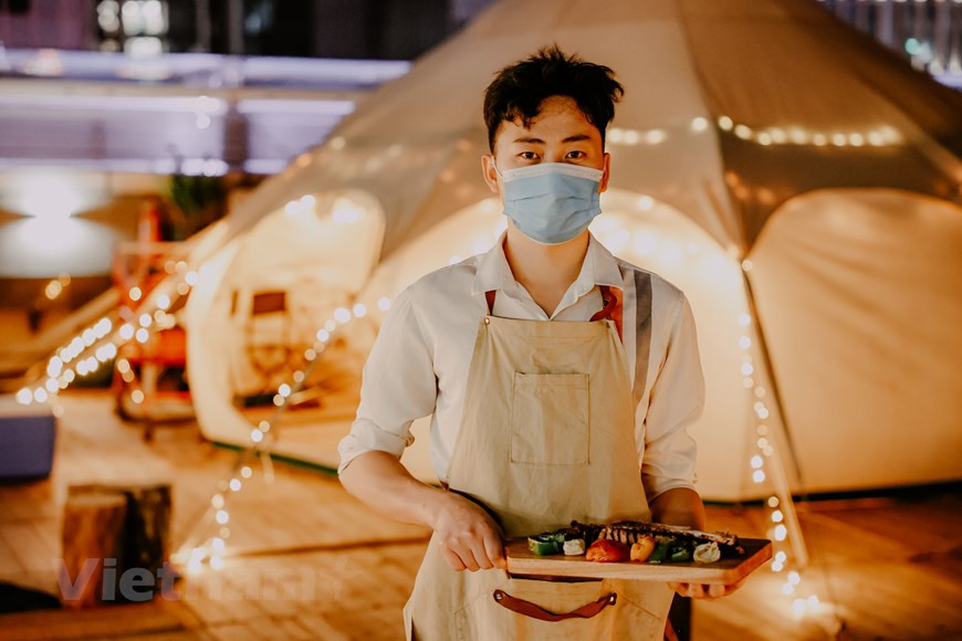 El glamping es definitivamente uno de los lugares interesantes que los hanoyenses deben visitar durante las próximas vacaciones. Ubicado en el séptimo piso del edificio Lotte Center, el glamorous camping cuenta con alrededor de 100 metros cuadrados e instalaciones para brindar mejores experiencias a los clientes. El glamping ofrece una amplia gama de servicios como comida, bebidas y música. Incluso si deseas cocinar tu propio plato, este lugar también tiene preparadas las parrillas y objetos para que los visitantes los experimenten por sí mismos y se sientan cómodos. Su horario es de las 18:00 a las 23:00 (hora local) todos los días, excepto el domingo, cuando abre desde el mediodía. Este sitio se ha convertido en un destino atractivo para los lugareños. (Foto: Vietnam+)