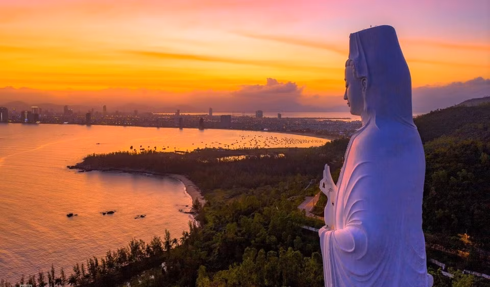 La puesta de sol cubre la península de Son Tra con un color amarillo anaranjado brillante.