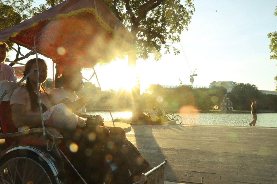 Turistas pasean el lago Hoan Kiem en triciclo (Foto: VNA)