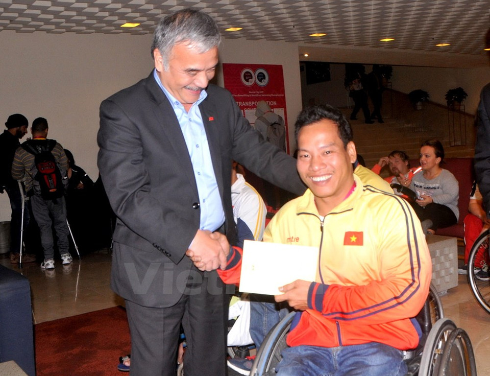 El embajador vietnamita en México, Nguyen Hoai Duong, felicita al halterófilo tras la victoria