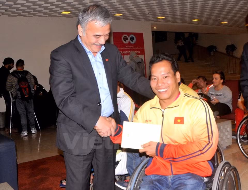 El embajador vietnamita en México, Nguyen Hoai Duong, felicita al halterófilo tras la victoria