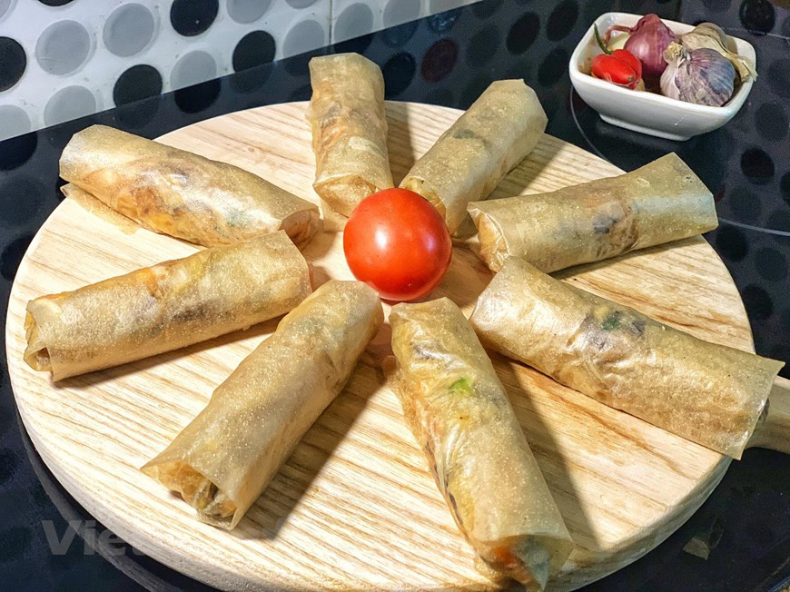 Los cocineros deben prestar atención al envolver la hoja de papel de arroz para que no se rompa a la hora de freír. (Foto: VNA)