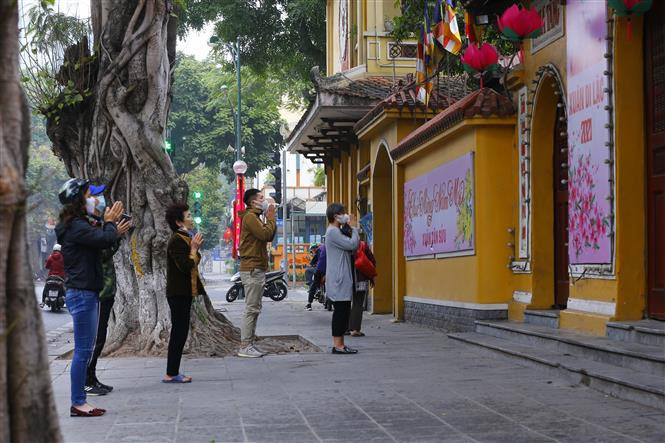 Los pobladores rezan al frente de la pagoda de Quan Su (Foto: VNA)