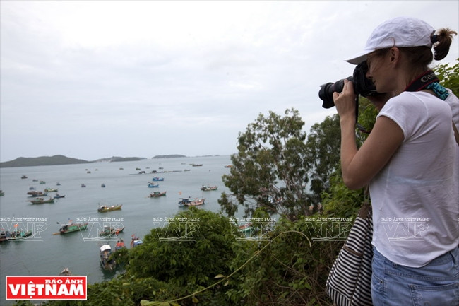 Una turista tomando foto en las islas de Nam Du. Foto: Kim Phuong/VNA