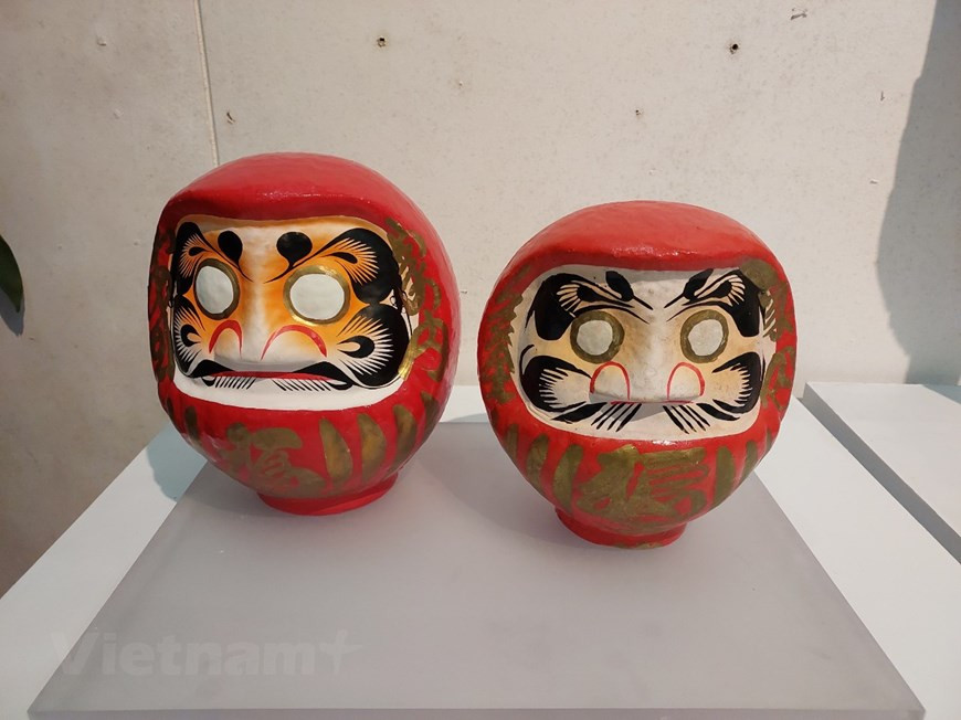 En Japón, los muñecos Daruma son figuras votivas sin brazos ni piernas y representan a Bodhidharma (Daruma en japonés), el fundador y primer patriarca del Zen. Dice la leyenda que el maestro Daruma perdió los brazos y las piernas de estar tantos años escondido en una cueva meditando y sin utilizarlos. Los colores típicos de Daruma son rojo, amarillo, verde y blanco. Un daruma con una sola pupila suele colocarse donde este sea visible, a manera de constante recordatorio del trabajo que debe hacerse para lograr el objetivo. Normalmente el muñeco Daruma es varón, aunque existe una muñeca Daruma, conocida como Ehime Daruma (Princesa Daruma). (Foto: Vietnam+)