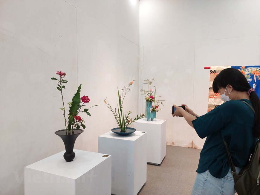 Visitantes descubren un rincón del arte japonés del arreglo floral Ikebana, en el cual se elaboran arreglos con una técnica en particular para expresar respeto y armonía hacia la naturaleza. Con una historia de más de 600 años, el tradicional arte japonés de aprovechar el espacio con arreglos de árboles, hojas, flores y otros elementos según las cuatro estaciones también está ganando adeptos en el extranjero. Considerado como una forma de meditación, este fomenta la relajación y el bienestar. Con el paso de los años, el Ikebana de Japón evolucionó, con variaciones y reglas estrictas, incrementando cada vez su nivel de complejidad y significado. (Foto: Vietnam+)