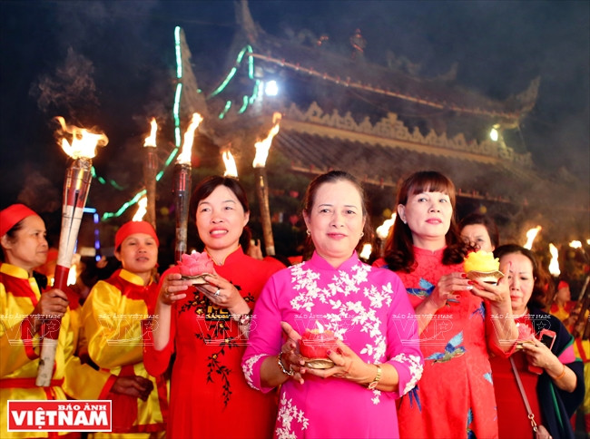 La bailarina de “Hau dong” Tran Thi Kim Hue (vestida ao dai rosa) durante la procesión de antorchas (Fuente: VNA)