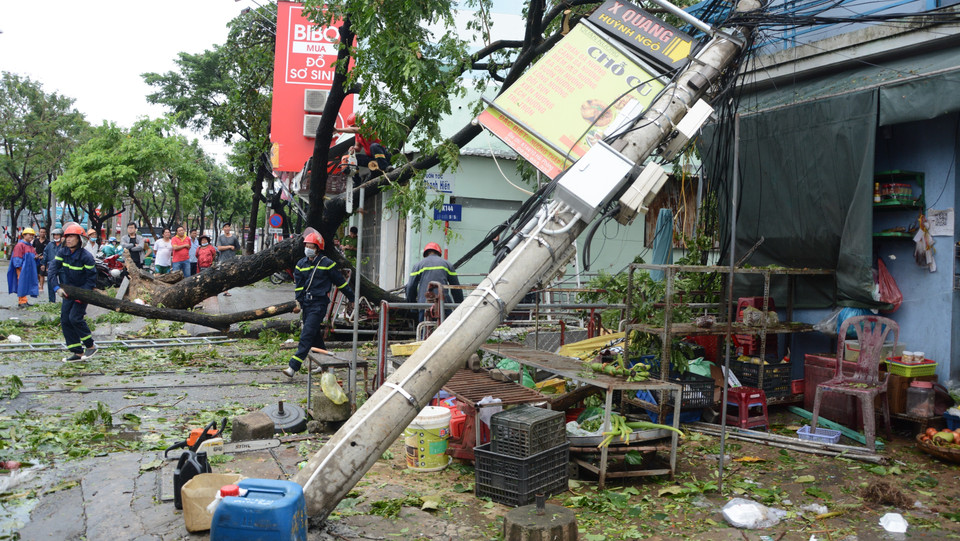 La fuerza policial de prevención y extinción de incendios en el distrito de Hai Chau, en la ciudad de Da Nang, coordina con las unidades relacionadas para manejar los postes eléctricos caídos sobre las casas (Fuente: VNA)