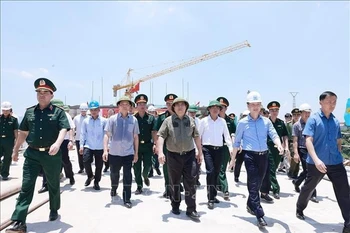 El primer ministro de Vietnam, Pham Minh Chinh, inspecciona el progreso del nuevo puente Phong Chau, en la provincia de Phu Tho (Foto: VNA)