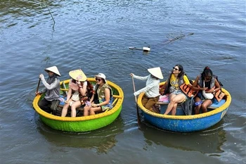 Los turistas disfrutan de paseos en bote cesta en el bosque de cocoteros (Foto: VNA)