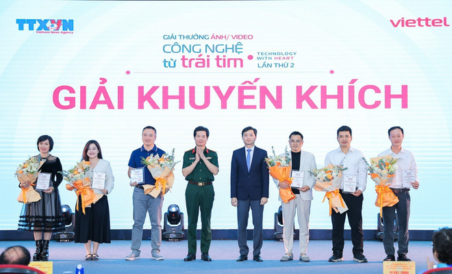 El secretario del Comité Central de la Unión de Jóvenes Comunistas Ho Chi Minh y presidente de la Unión de Estudiantes de Vietnam, Nguyen Minh Triet, y el teniente coronel Vo Thanh Hai, jefe de Marca y Comunicaciones de Viettel y subjefe del Comité Organizador del Premio, entregaron los premios de mención de honor a los autores. (Foto: VNA) vna-potal-le-trao-giai-thuong-cong-nghe-tu-trai-tim-lan-thu-2-8357804.jpg