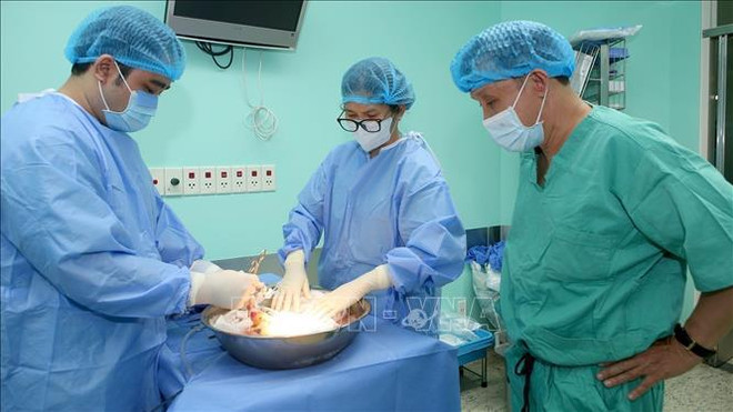 El profesor Pham Nhu Hiep, director del Hospital Central de Hue (a la derecha), dirige la realización de un trasplante de órganos procedentes de un donante con muerte cerebral en el Hospital Vietnam-Suecia en Uong Bi, provincia de Quang Ninh. (Fuente: VNA) ghe-tang-31524h.jpg