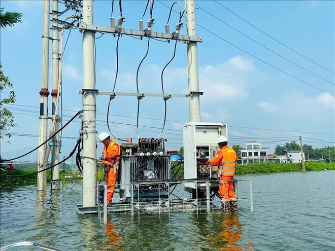 Con el fin de garantizar la seguridad del suministro eléctrico y ayudar a las personas en las zonas inundadas, la Compañía de Electricidad Quoc Oai envió fuerzas para monitorear de cerca la situación y realizar el levantamiento del cable eléctrico fuera del agua. (Fuente:VNA) tram-bien-ap-180924.jpg