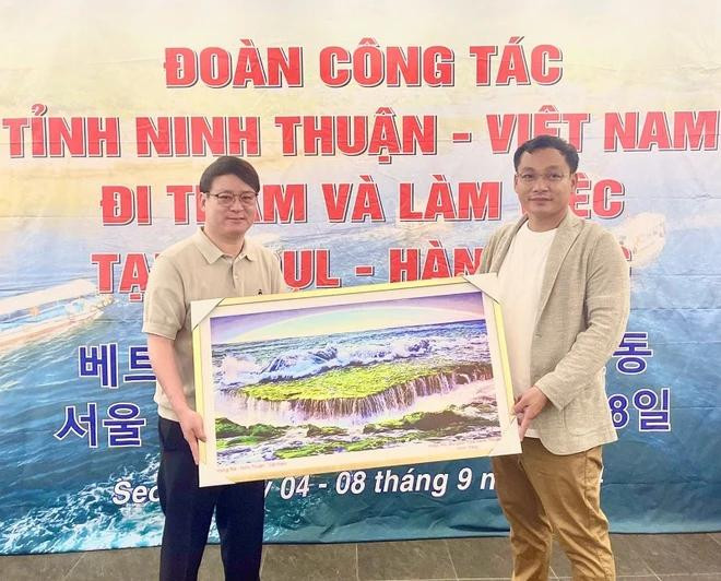 El presidente de la Asociación de Turismo de Ninh Thuan, Nguyen Anh Vu, entrega regalo a Yang Bo Yoo, representante de la Asociación del Turismo de Corea del Sur. (Foto: VNA) ninh-thuan-1-7730.jpg.webp