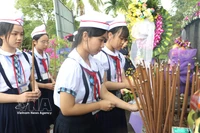 Estudiantes ofrecen incienso en memoria de los fallecidos. Foto: Dinh Huong – VNA