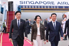 El ministro vietnamita de Ciencia y Tecnología, Nguyen Manh Hung, recibe al primer ministro de Singapur, Lawrence Wong, y su esposa en el aeropuerto de Noi Bai. (Fuente: VNA)