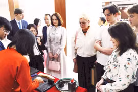 Los turistas extranjeros disfrutan al experimentar la impresión de xilografías. (Fuente: nhandan.vn)