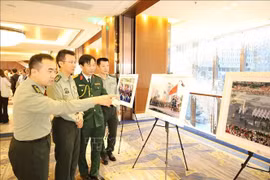 Delegados chinos visitan una exposición fotográfica del desfile militar que celebra el 80 aniversario del Día Nacional de Vietnam. (Fuente: VNA)