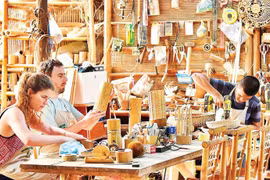 Turistas elaboran sus propios recuerdos de bambú en un taller artesanal de Da Nang. (Fuente: nhandan.vn)