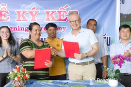 Thi Khui, directora de a Cooperativa Agrícola de Anacardo Orgánico Trang Co Bu Lach, firma un acuerdo de cooperación un representante de la empresa Intersnack Vietnam. (Fuente: Periódico Dong Nai) 