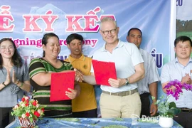 Thi Khui, directora de a Cooperativa Agrícola de Anacardo Orgánico Trang Co Bu Lach, firma un acuerdo de cooperación un representante de la empresa Intersnack Vietnam. (Fuente: Periódico Dong Nai) 