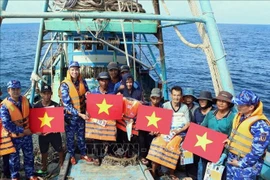 Las autoridades entregan banderas nacionales y chalecos salvavidas a los pescadores en alta mar. (Fuente: VNA)