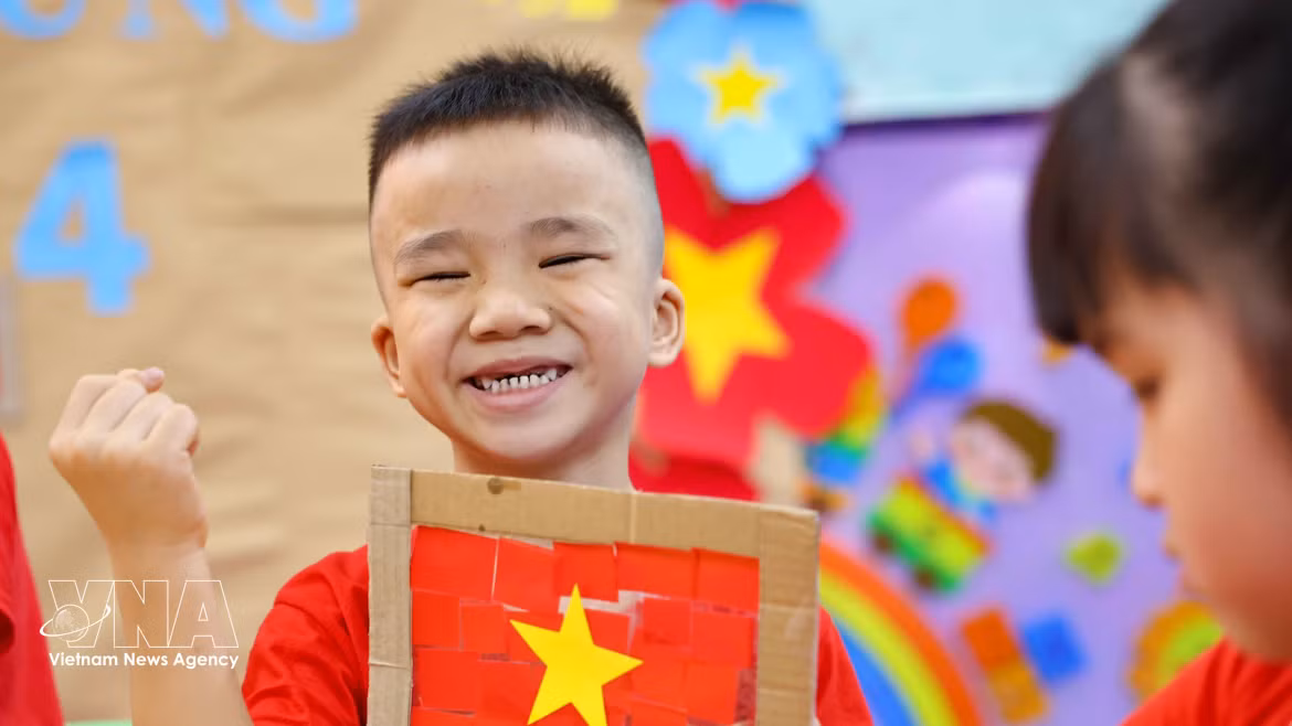 Niños vietnamitas entusiastas con la creación de la bandera nacional 