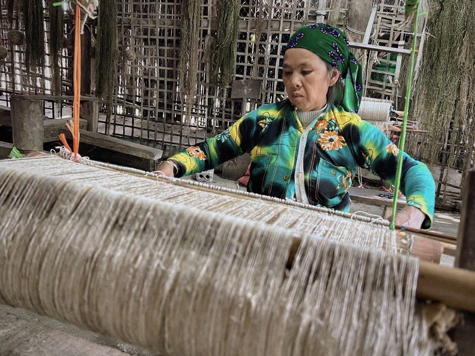 Una mujer Hmong en la aldea textil Lung Tam tejiendo telas a mano en telares de madera tradicionales. (Foto: VNA)