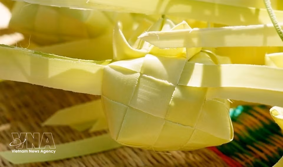 Las envolturas del pastel Ka tum se tejen cuidadosamente con hojas tiernas de palmera de azúcar, creando un rasgo distintivo de este pastel tradicional del pueblo khmer en la región de Bay Nui, An Giang. (Foto: VNA)