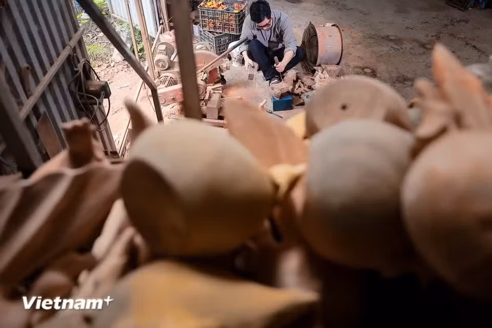 El artesano utiliza materiales locales como madera de jackfruit, bambú y laterita - un material característico que define el alma de la arquitectura de la antigua aldea de Duong Lam - para dar forma a estas esculturas únicas. (Fuente: Vietnam+)
