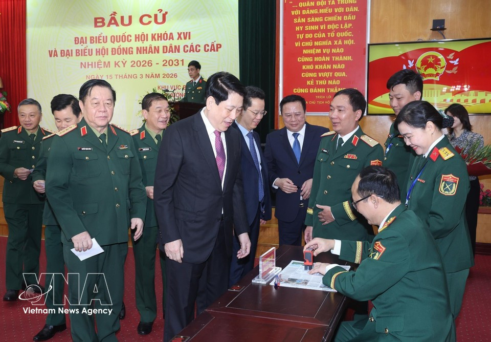 El presidente del Estado, Luong Cuong, recibe su tarjeta de elector sellada para confirmar que ha emitido su voto en el colegio electoral número 26 del barrio de Hoan Kiem, en Hanoi. (Foto: VNA)