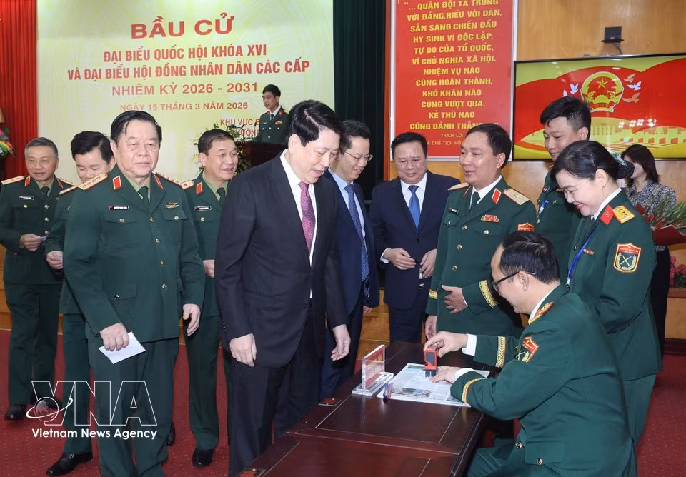 El presidente del Estado, Luong Cuong, recibe su tarjeta de elector sellada para confirmar que ha emitido su voto en el colegio electoral número 26 del barrio de Hoan Kiem, en Hanoi. (Foto: VNA)