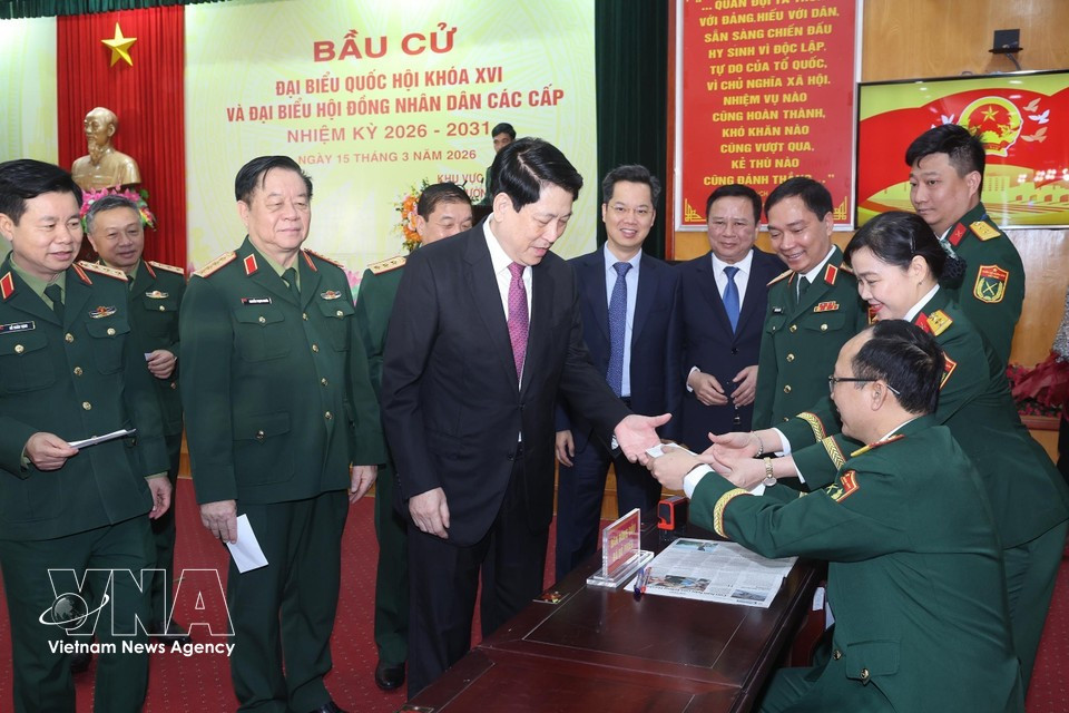 El presidente del Estado, Luong Cuong, recibe su tarjeta de elector sellada para confirmar que ha emitido su voto en el colegio electoral número 26 del barrio de Hoan Kiem, en Hanoi. (Foto: VNA)