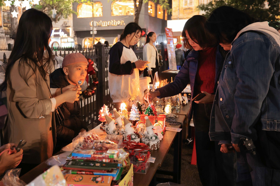 Las personas van a comprar complementos relacionados con la Navidad en la zona de la Catedral de San José en Hanoi. Foto: VNA