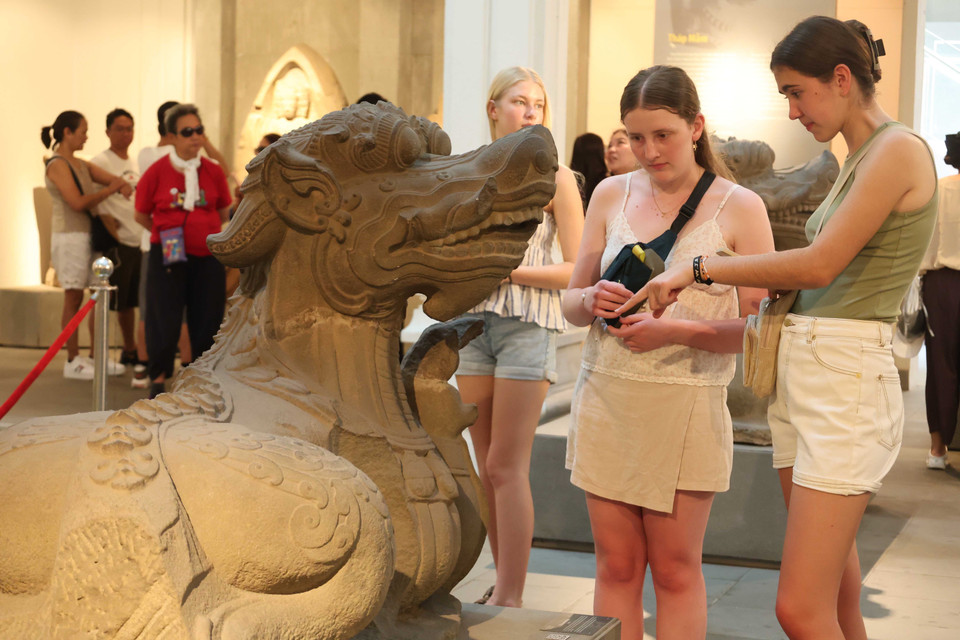 Visitantes extranjeros exploran la estatua del monstruo acuático Makara en la cultura Cham. Foto: VNA