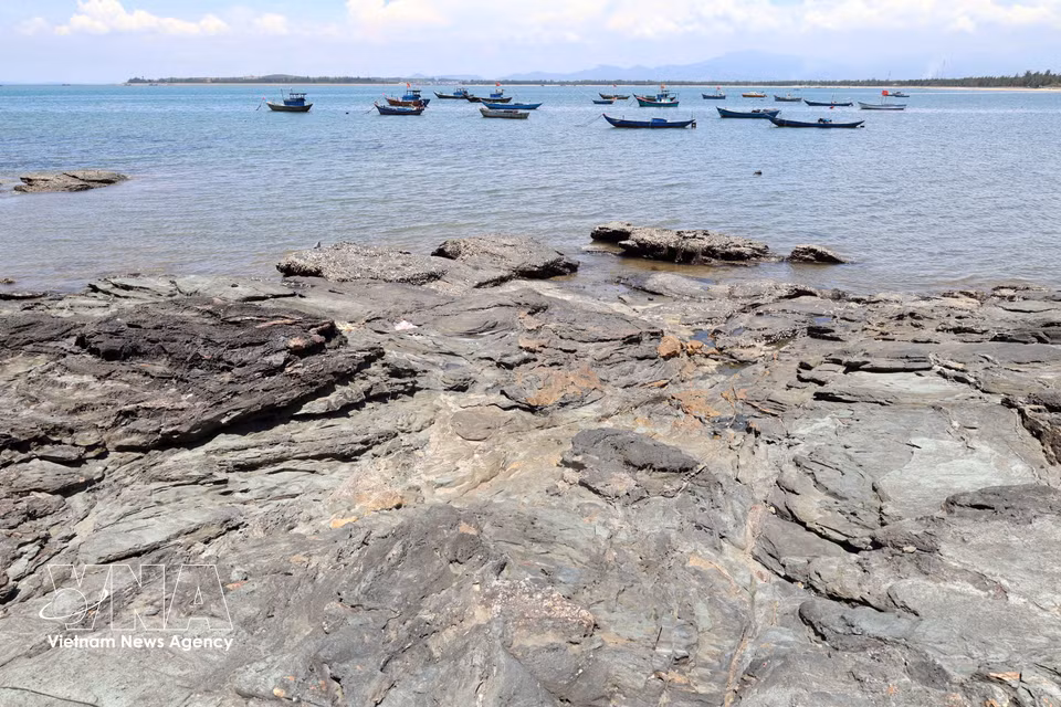 Los afloramientos de roca negra de la zona de Ban Than se extienden hacia el mar. Foto: VNA