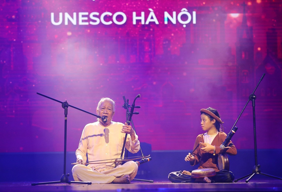 Xuan Hoach, uno de los tres artistas vietnamitas reconocidos por la organización World Masters como Maestros del Mundo, actuó junto a su nieta durante el programa. Foto: VNA