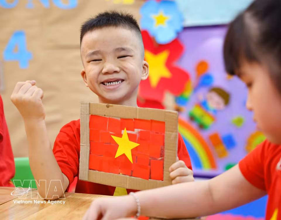 Los niños se sienten muy felices y orgullosos al completar su propia bandera nacional. Foto: VNA