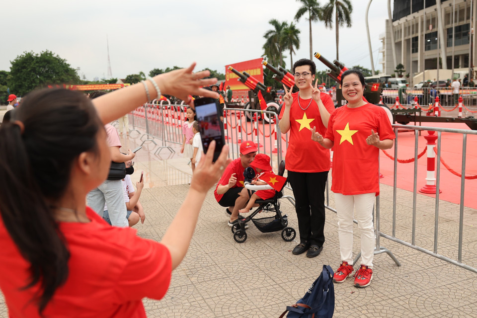 Personas se toman fotos con entusiasmo junto a la artillería ceremonial en el Estadio de My Dinh. Foto: VNA