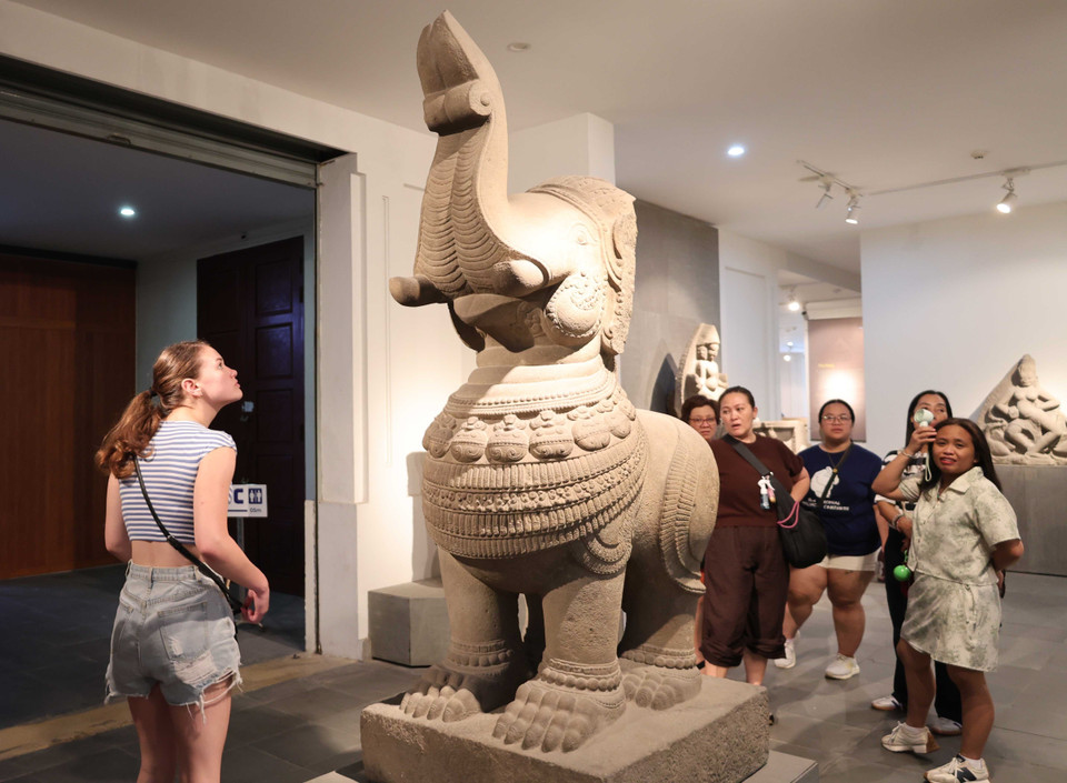 Visitantes extranjeros exploran los artefactos expuestos en el museo. Foto: VNA