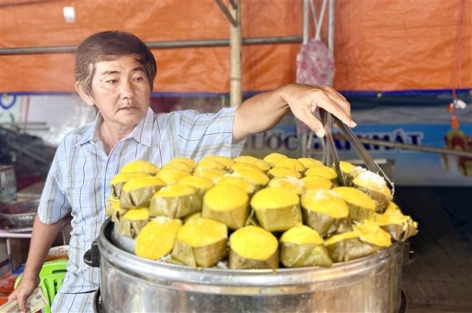 Artesanos preparando el "Banh Bo thot not", un pastel al vapor hecho con savia de palma azucarera, que es esponjoso y aromático. Foto: VNA