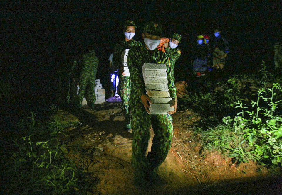 Soldados trabajan durante la noche para traer materiales para la construcción de viviendas para personas de bajos recursos. Foto: VNA