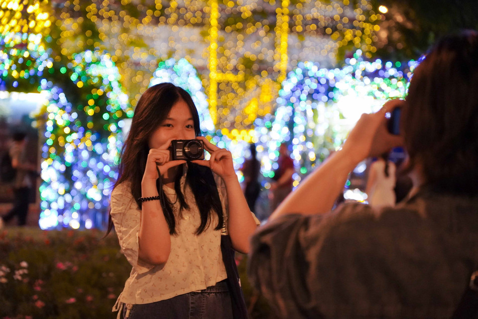 Los jóvenes aprovechan la oportunidad para capturar momentos de la celebración navideña en Ciudad Ho Chi Minh. Foto: VNA