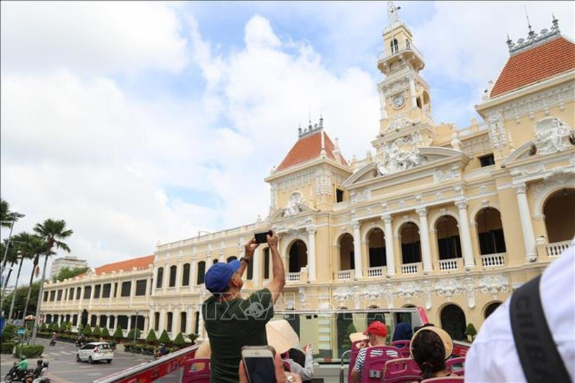 Visitantes internacionales exploran el centro de Ciudad Ho Chi Minh en un autobús de dos pisos. (Foto: VNA)