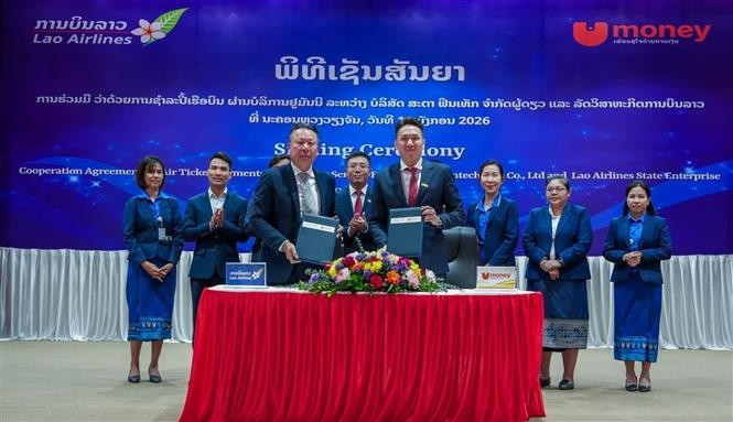Ceremonia de firma del acuerdo de cooperación para el pago de billetes de avión a través del servicio UNITEL entre Star Fintech y Lao Airlines. (Foto: VNA)
