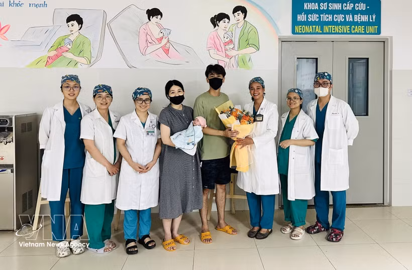 El personal médico del Hospital de Obstetricia y Pediatría de Da Nang entrega flores para felicitar a los padres y al bebé al momento del alta hospitalaria. (Foto: VNA)