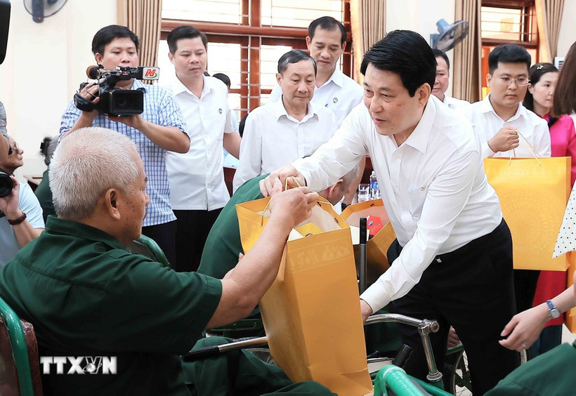 El presidente Luong Cuong entrega obsequios a Nguyen Xuan Mai, inválido de guerra, quien recibe tratamiento en el Centro de Rehabilitación de Veteranos de Guerra de Duy Tien. (Foto: VNA)