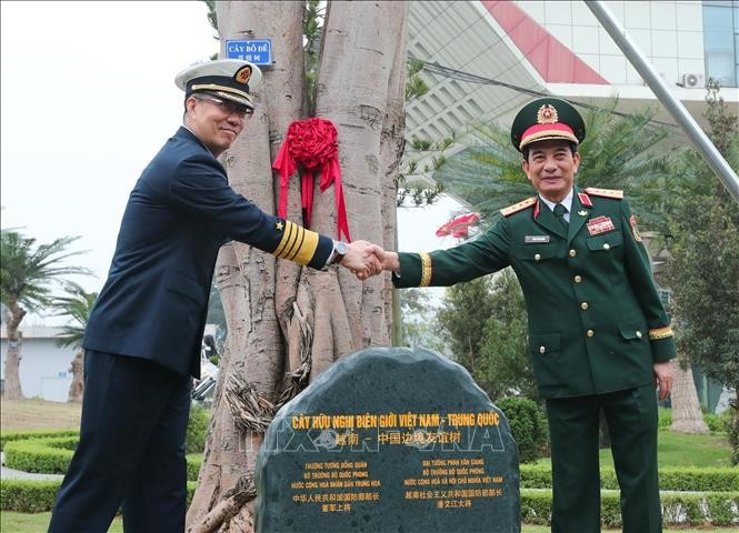 El ministro de Defensa de Vietnam, general Phan Van Giang, y su homólogo chino, coronel general Dong Jun, plantan un árbol en el puesto fronterizo internacional de Huu Nghi. (Foto: VNA)