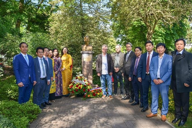 El personal de la Embajada y las agencias representativas vietnamitas en Francia toman fotografías de recuerdo en la estatua del tío Ho. (Foto: VNA)