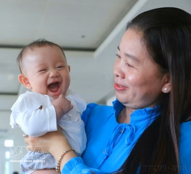Una niña acompaña a su madre en la ceremonia de reconocimiento a familias ejemplares con dos hijas, organizada por la provincia de Hau Giang el 5 de enero de 2023. (Foto: VNA)